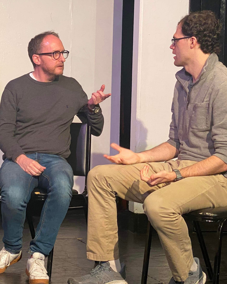 Nottingham improviser Lloydie James Lloyd is pictured with New York / Amsterdam improviser Rick Andrews. Both are sitting down. Lloydie is gesticulating towards Rick.
